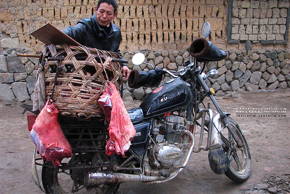 Man selling pork via motorbike - in Xiang Yun Town